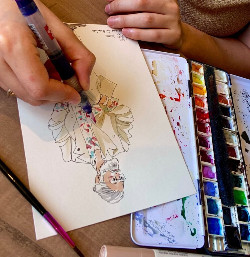 Close-up of a live fashion illustration painted during a luxury boutique event in Paris.